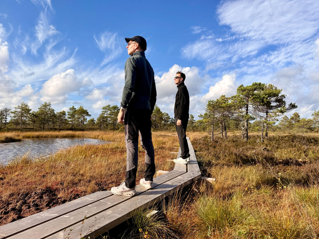David und André auf einem Holzsteg in einer herbstlichen Moorlandschaft.