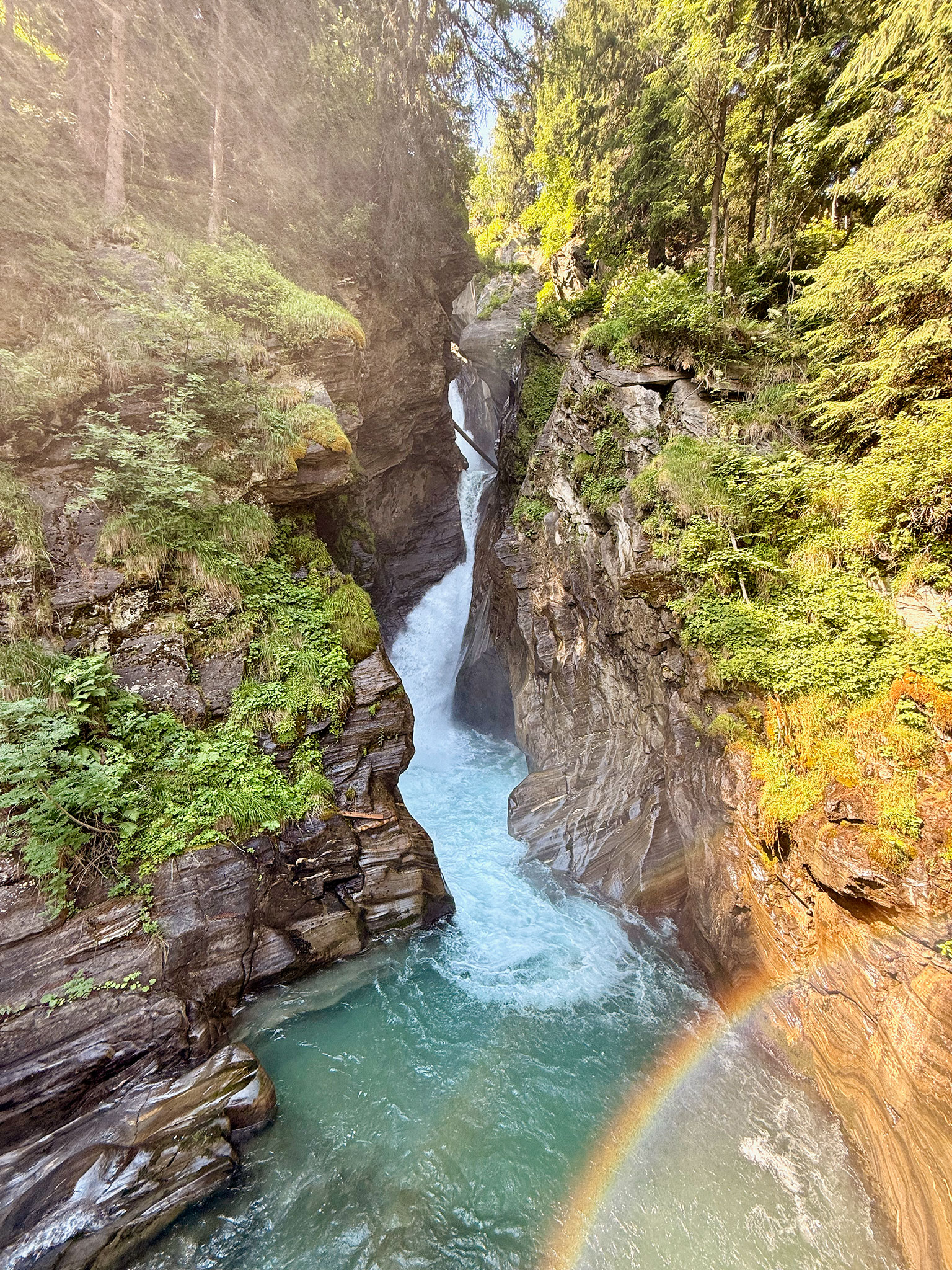 Stieber Wasserfall bei Moos in Passeier zwischen steilen Felswänden und grüner Vegetation.